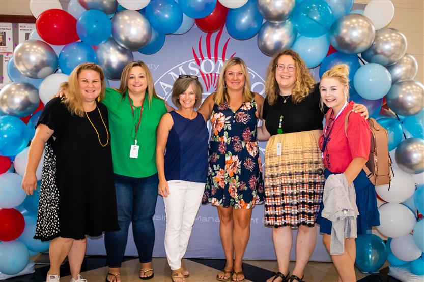 A group of teachers smile
